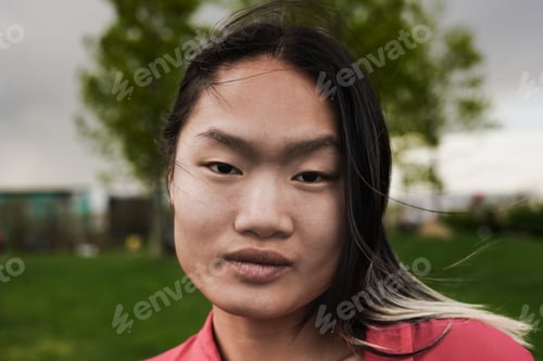 Preview: Young asian woman looking on camera outdoor