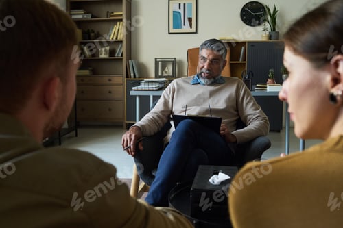 Preview: Middle Aged Indian Man Counseling Young Multiethnic Couple in Office