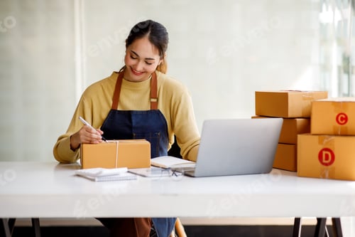 Preview: Startup small business entrepreneur of freelance Asian woman using a laptop with box Cheerful succes