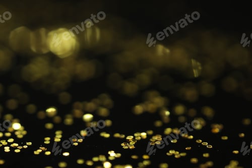 Preview: Beautiful shiny golden glitter on black background, closeup
