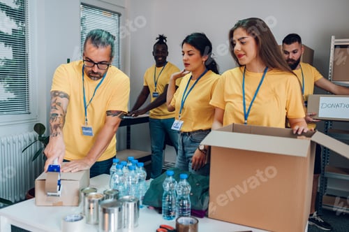 Preview: Group of multiracial volunteers working in community charity donation center