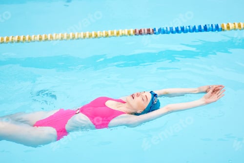 Preview: gorgeous woman in pink swimwear relaxing in the resort
