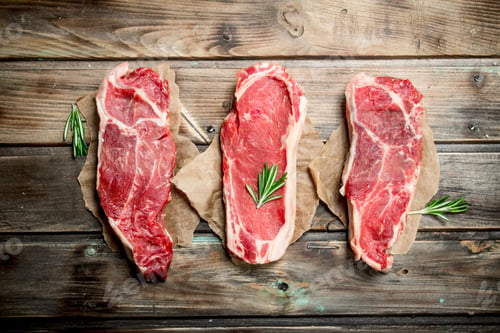 Preview: Raw marbled beef steaks with rosemary.