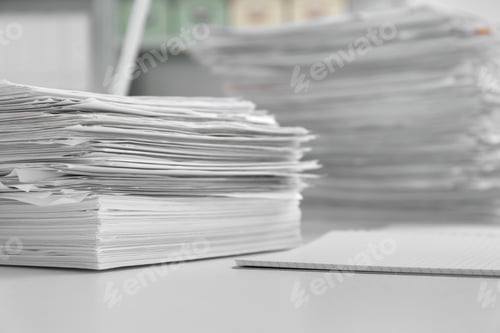 Preview: Stacks of documents on table in office