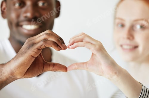 Preview: Black and white. Cropped portrait of African man and Caucasian woman looking and smiling at the came