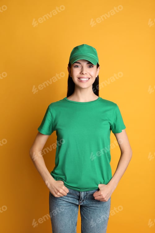 Preview: Young happy woman in green cap and tshirt on yellow background. Mockup for design