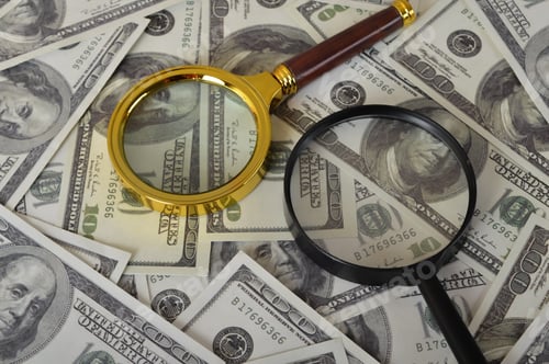 Preview: Magnifying glass and heap of dollars. Financial concept.