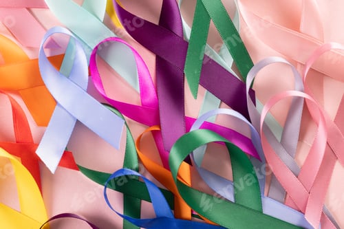 Preview: Extreme close-up of various colorful awareness ribbons on pink background, copy space