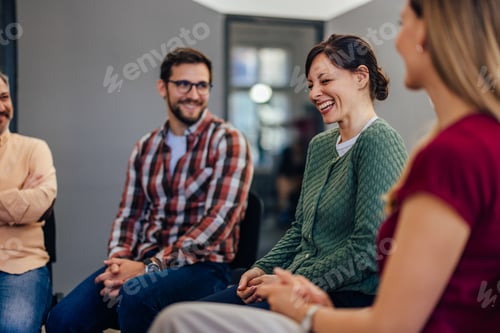 Vista previa: Grupo sonriente de personas que participan en una discusión en un ambiente informal