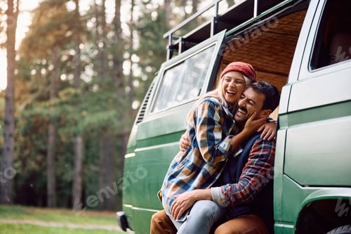 Preview: Cheerful couple of campers having fun in their van at trailer park.