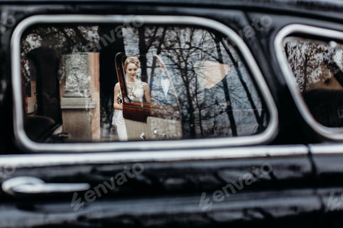 Preview: Stylish wedding couple sitting in beautiful black car