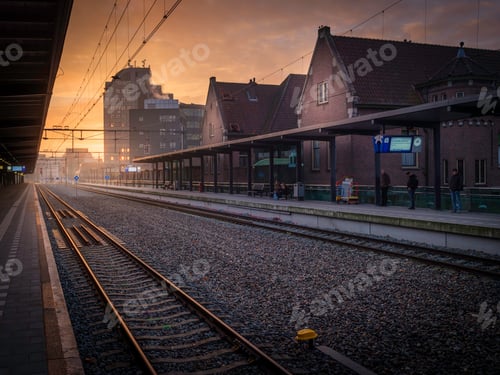 Preview: a train on the tracks with people standing on it in the sun setting