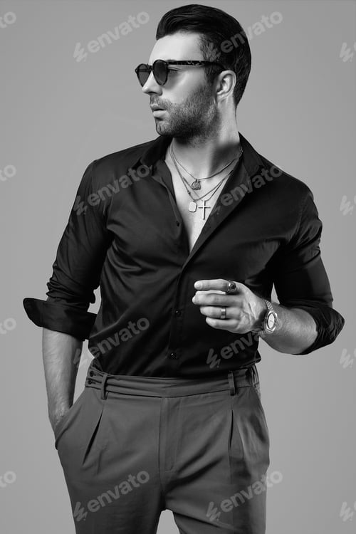 Preview: Studio Portrait Of A Beautiful Brutal Tanned Hipster Man In A Black Shirt And Glasses