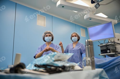 Preview: Surgeons Standing by Operating Table in Hospital Room