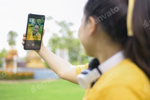 Preview: A young woman taking a selfie with a smartphone.