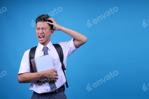 Preview: Upset Unhappy Young Indonesian Guy In High School Student Uniform Squeezing Head With Hands