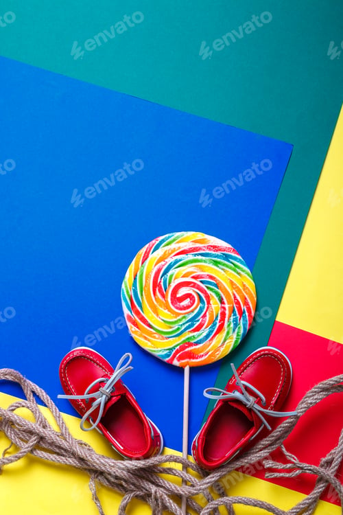 Preview: Small red boat shoes near big multi-colored lollipop