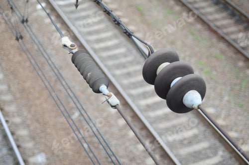 Preview: Electrical insulators on the contact wires on the background of a blurred railway track