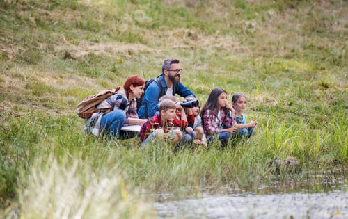 Preview: Group of school children with teacher on field trip in nature