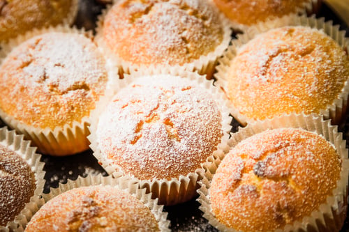 Preview: Homemade apple muffins with white sugar powder on wooden table