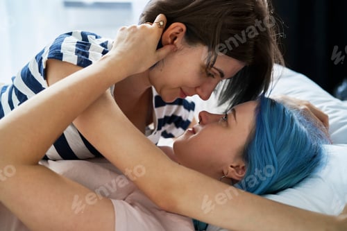 Preview: Close up of lesbian couple cuddling intimately in bed