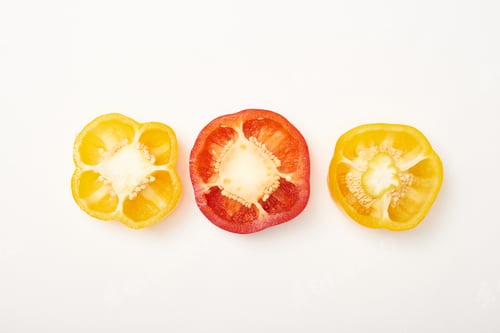 Preview: Studio shot of cut yellow and red bell peppers on white background