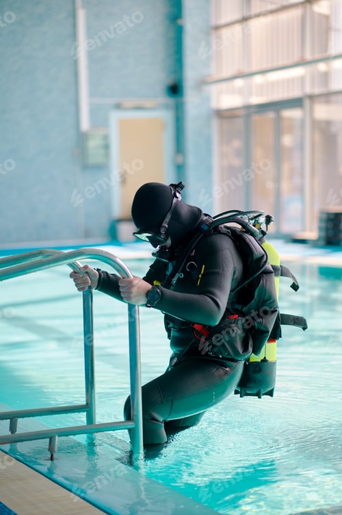 Preview: Male diver in scuba gear climb out of the pool