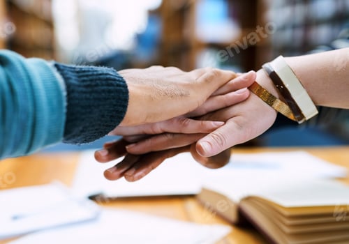 Preview: Cropped shot of a group of students stacking their hands on top of each other