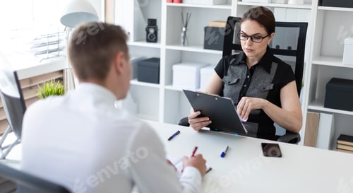 Preview: Young people sit in the office at the computer table and work with documents.
