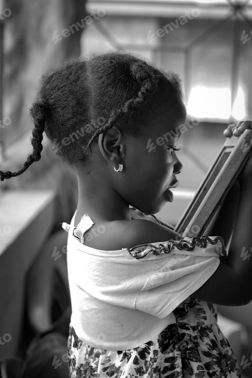 Preview: Young Child Looking at a Picture Frame Indoors
