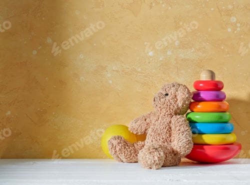 Preview: old teddy bear and wooden toy on a wooden shelf
