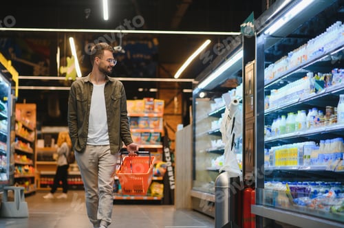 Preview: Handsome man shopping in a supermarket