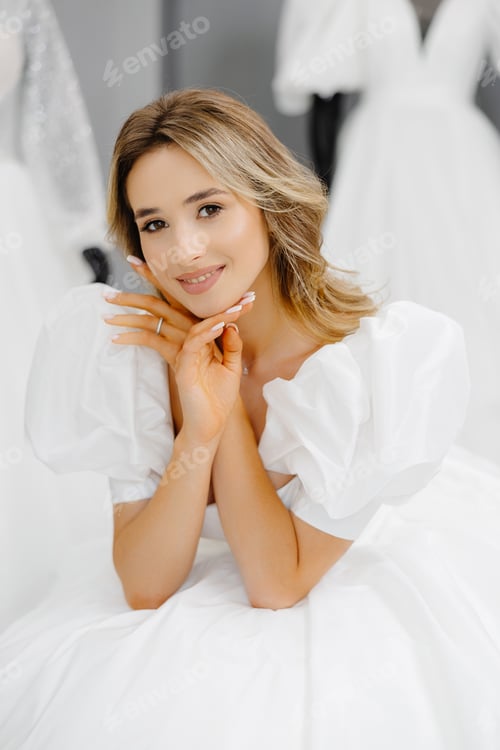 Preview: Pretty young woman is choosing a wedding dress in the shop