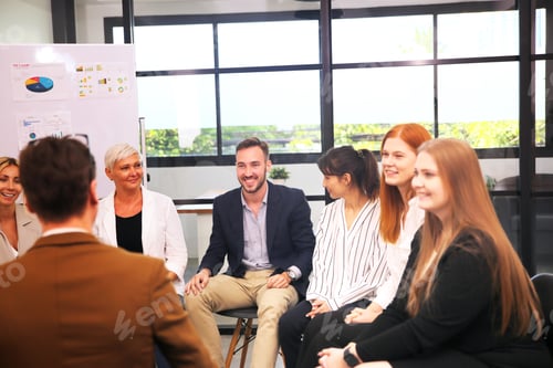 Preview: Shot of a mature businesswoman sitting and training her team in the office.