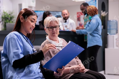 Preview: Asian nurse explaining diagnosis to elderly patient