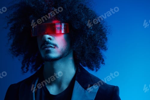 Preview: Fashion portrait of a man with curly hair on a blue background wearing red sunglasses, multinational