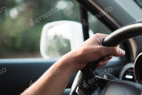 Preview: The driver's hand on the steering wheel of the car. Driving, traffic rules, safety at the wheel.