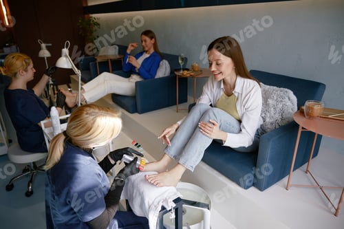 Preview: Attractive woman friends gossiping whispering secrets at nail studio