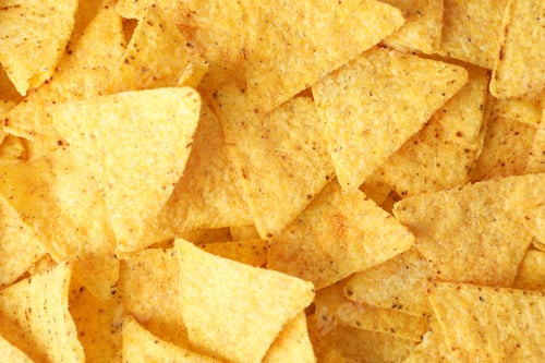 Preview: Tasty Mexican nachos chips as background, top view