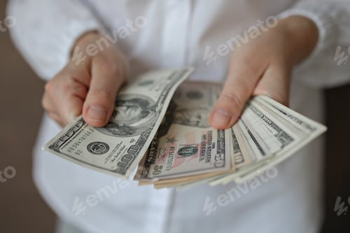 Preview: A woman holding money.