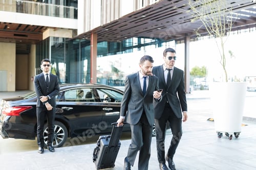 Preview: Businessman With Luggage Walking By Bodyguard