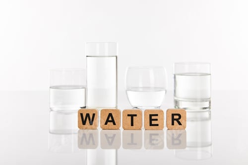 Preview: clear fresh water in glasses near cubes with water lettering isolated on white
