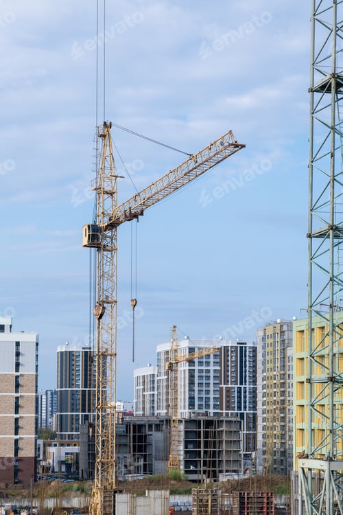 Preview: crane and a building under construction against a blue sky background