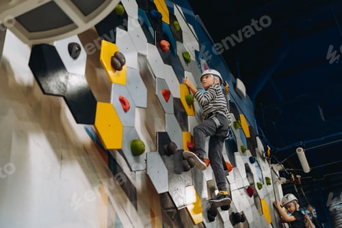 Preview: caucasian boy climbing in adventure park passing obstacle course. high rope park indoors