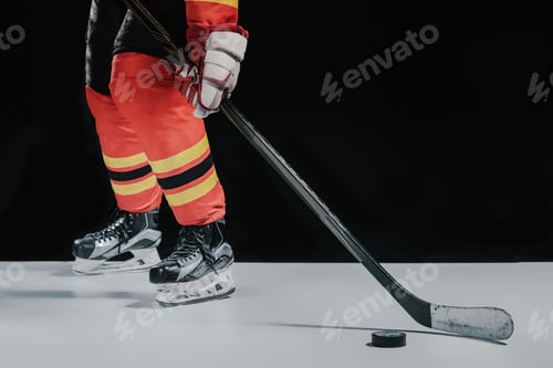 Preview: low section of professional sportsman playing hockey on black