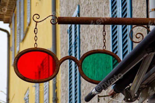 Preview: Low angle shot of a red and green glasses sign on a street
