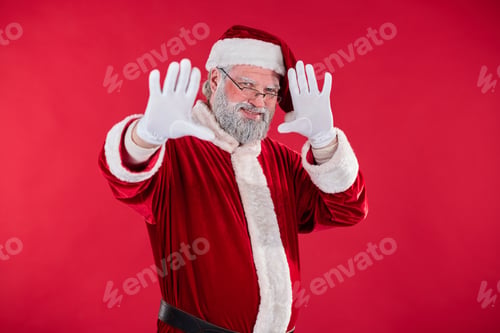Preview: Smiling Santa Claus Waving Against Red Background
