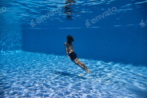 Preview: Boy swimming towards surface of tiled pool
