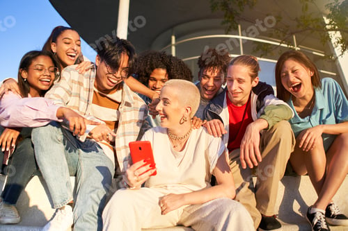 Preview: Multiracial people having fun together watching cell phone screens outdoors. Gen Z