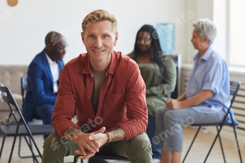Preview: Smiling Man Sitting with Group Therapy Attendees